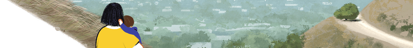 A mother hugging her child while looking at the ocean.